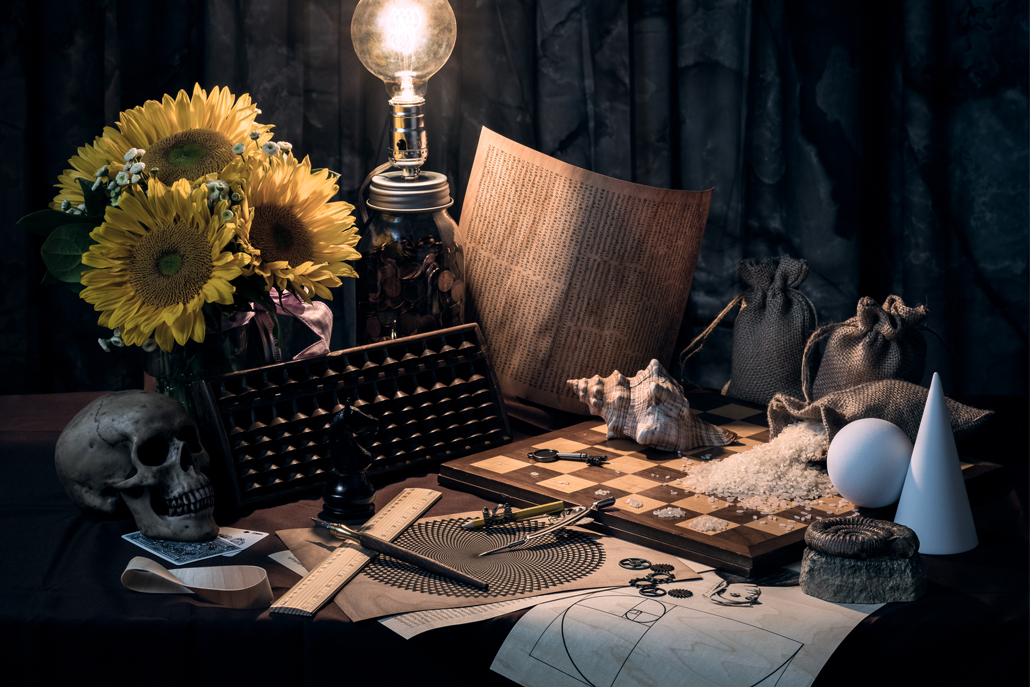 ﻿Desk with drawings, chess board, flowers, light and skull